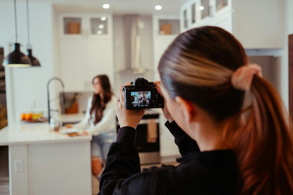 Creator filming content on a phone in a kitchen